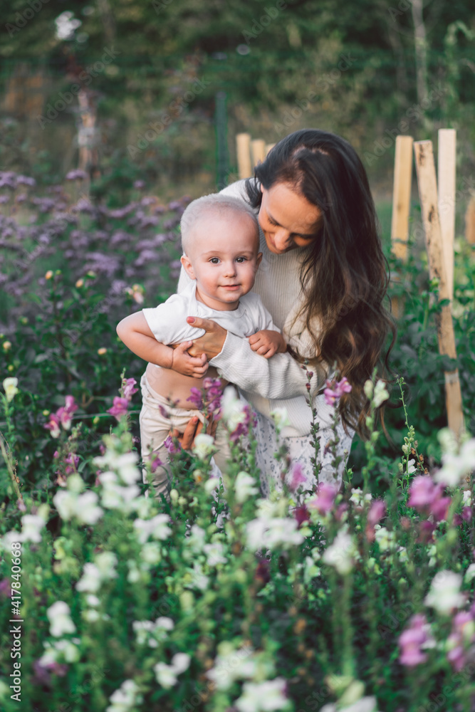 Woman playing with her child in a greenhouse with flowers Woman playing with her child in a greenhouse with flowers
