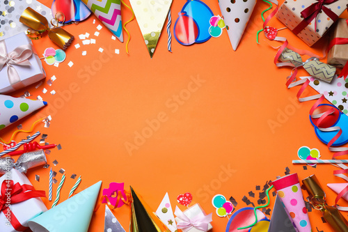 Frame of party items on orange background, flat lay. Space for text