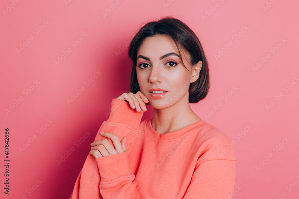 Portrait of beautiful smiling cute brunette woman model in casual peach sweater clothes with bright makeup and pink lips isolated Portrait of beautiful smiling cute brunette woman model in casual peach sweater clothes with bright makeup and pink lips isolated