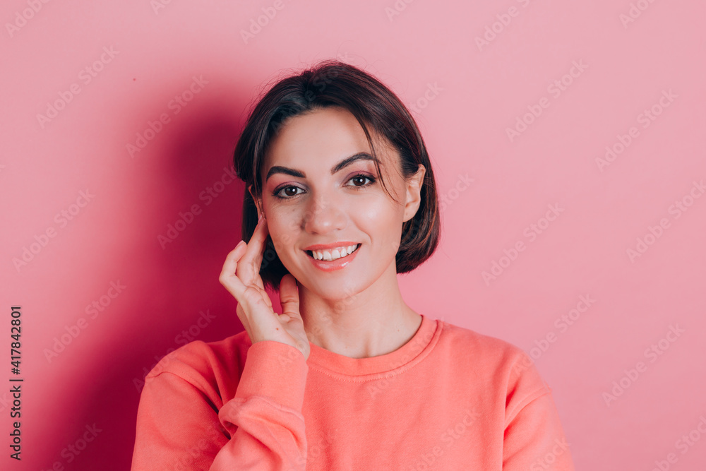 Portrait of beautiful smiling cute brunette woman model in casual peach sweater clothes with bright makeup and pink lips isolated Portrait of beautiful smiling cute brunette woman model in casual peach sweater clothes with bright makeup and pink lips isolated