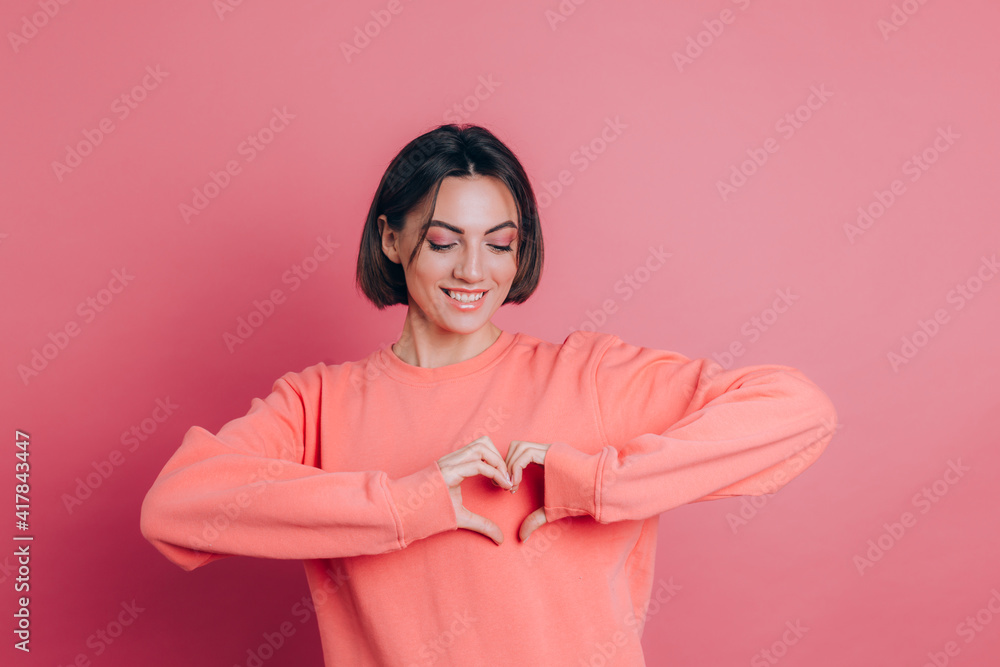 Funny young woman 20s in casual clothes isolated on pink background studio portrait. Love concept. Mock up copy space. Shows heart with hands. Funny young woman 20s in casual clothes isolated on pink background studio portrait. Love concept. Mock up copy space. Shows heart with hands.