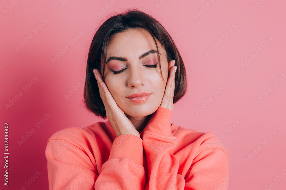 Portrait of beautiful smiling cute brunette woman model in casual peach sweater clothes with bright makeup and pink lips isolated Portrait of beautiful smiling cute brunette woman model in casual peach sweater clothes with bright makeup and pink lips isolated