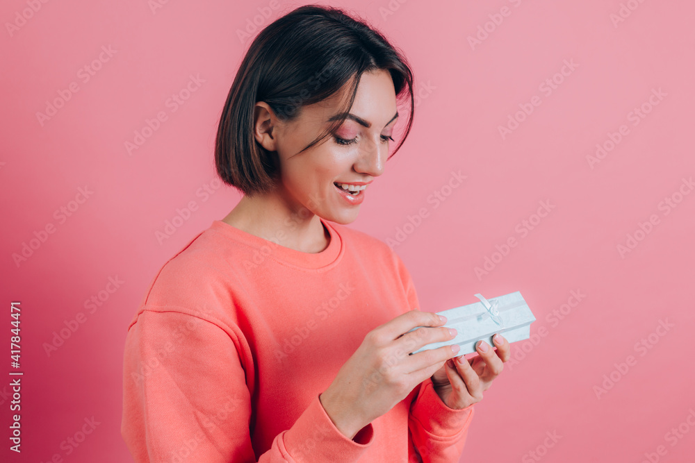 Portrait of happy smiling girl opening gift box isolated on pink background Portrait of happy smiling girl opening gift box isolated on pink background