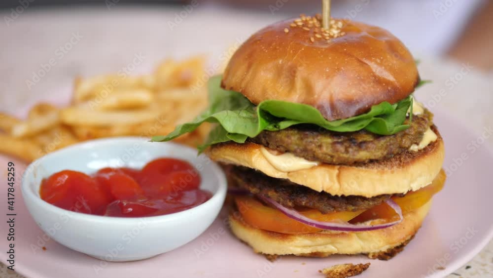 Close up of vegan burger served with sweet potato fries and ketchup. Healthy delicious plant-based meals Close up of vegan burger served with sweet potato fries and ketchup. Healthy delicious plant-based meals