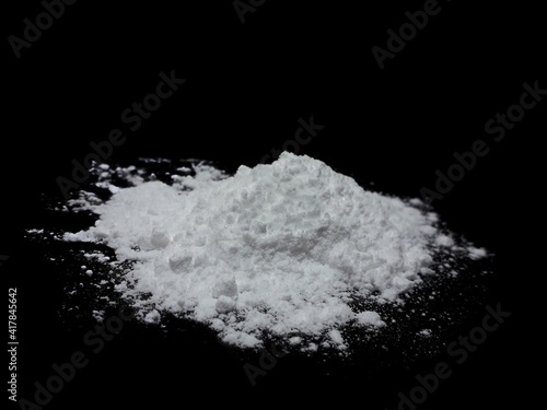 Cocaine drug powder pile on black background