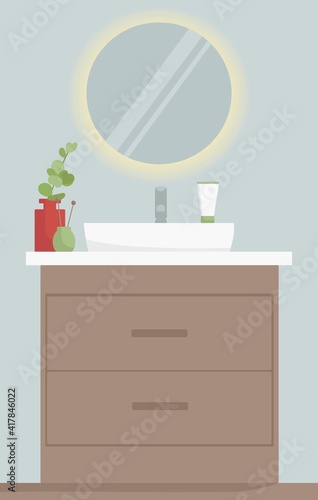 Vector illustration of a bathroom interior. The bathroom has a round illuminated mirror. There is a storage cabinet under the sink.  © Анастасия Маленко