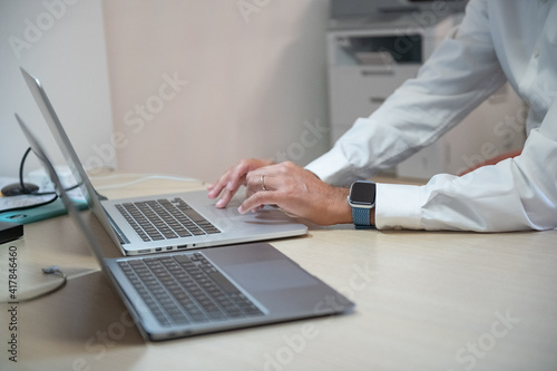 Man working with his laptop in the office, detail on hands