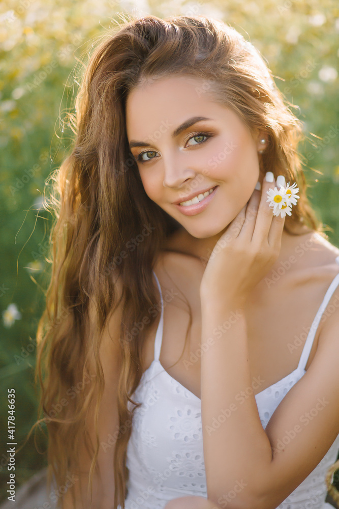 Super beautiful model woman with an amazing smile and a good happy mood Looks into the camera with a cosmic look Long gorgeous hair Delicate white dress in sunny summer weather Yellow field Super beautiful model woman with an amazing smile and a good happy mood Looks into the camera with a cosmic look Long gorgeous hair Delicate white dress in sunny summer weather Yellow field