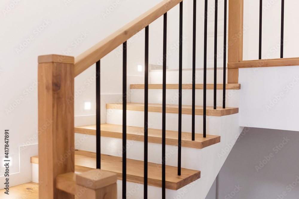 Obraz premium Wood staircase inside contemporary white modern house.