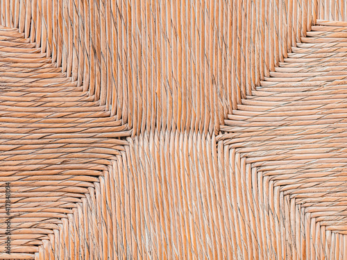 Geometric pattern of seat of a wicker chair.  Furniture in a cafe, a restaurant. Beige color. Part of interior