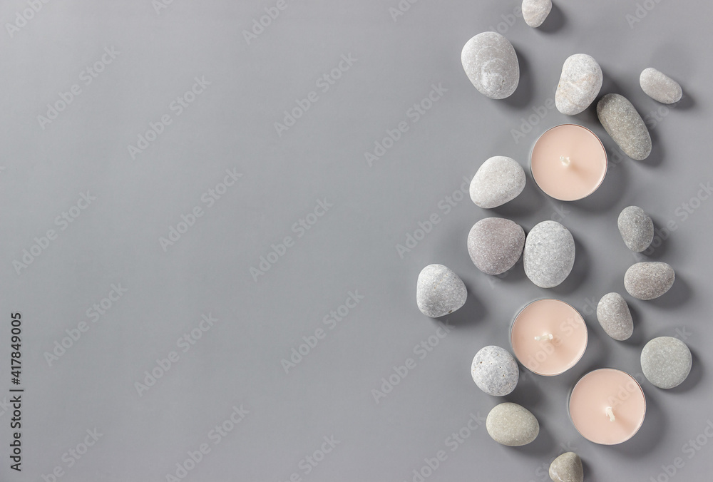 Aromatic candles and stones on a gray background. Spa composition. Relaxation and zen like concept. Flat lay. Copy space Aromatic candles and stones on a gray background. Spa composition. Relaxation and zen like concept. Flat lay. Copy space