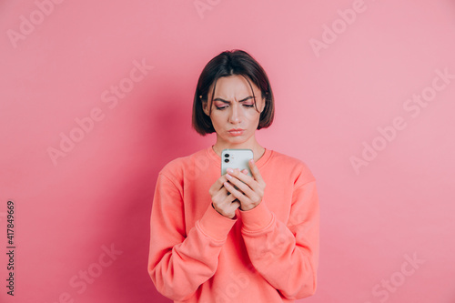 Papier peint Young woman is feeling sad unhappy angry while reading sms using her mobile phon