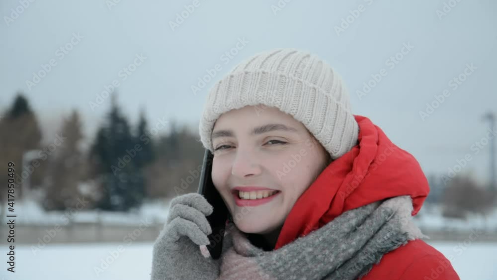 Close up russian hipster girl face talking on the phone outside winter time Close up russian hipster girl face talking on the phone outside winter time