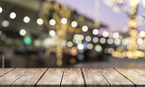 Empty wooden table top with lights bokeh on blur restaurant background.