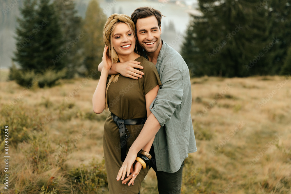 Young happy couple in love hugging smiling and having fun in the mountains Young happy couple in love hugging smiling and having fun in the mountains