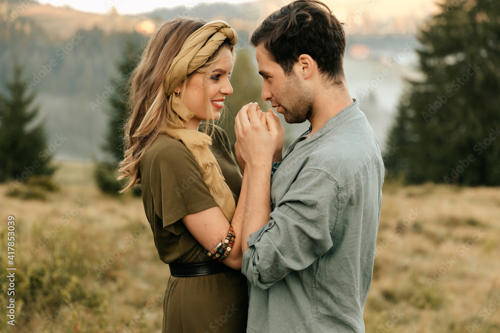 Young happy couple in love hugging and holding hands beautifully in the mountains Young happy couple in love hugging and holding hands beautifully in the mountains