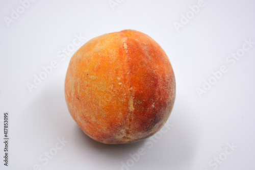 Tasty and useful fresh fruits, ripe red and orange peaches with a terry white skurt are located on a white background.  photo