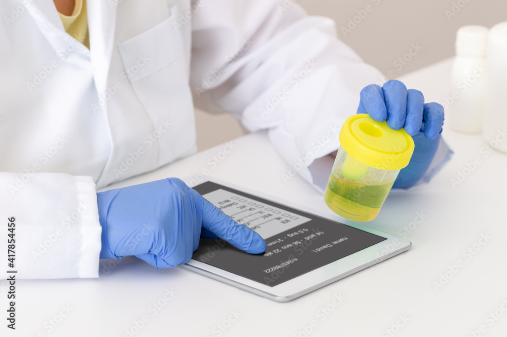 Closeup shot of a scientist examining a urine sample and recording findings in a lab in her tablet Closeup shot of a scientist examining a urine sample and recording findings in a lab in her tablet