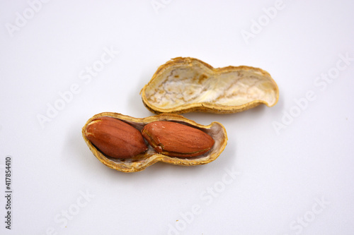Delicious and useful nuts, brown dried peanuts in its shell, shell dismissed on a white background. 