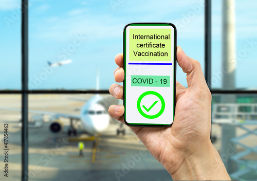 Businessman using a mobile phone with digital International certificate of Covid-19 Vaccination at airport. The certificate indicates that the holder has been vaccinated against Coronavirus Covid-19