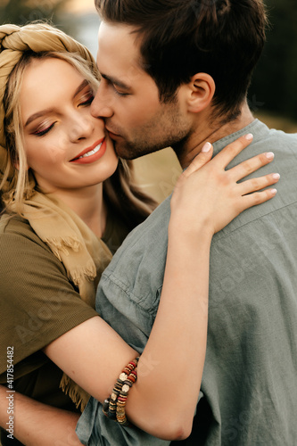 A loving guy kisses his beloved girlfriend on the cheek