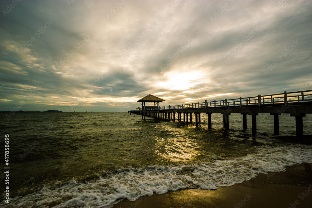 Fototapeta premium wood bridge in evening at Casaluna village in Thailand , wooden pier on the beach ,Wooded bridge in the port between sunrise.