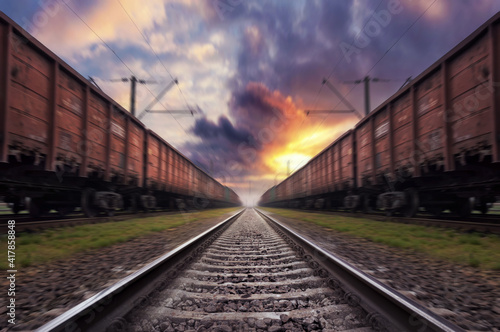 Railroad in motion with blur effect at sunset with dramatic sky.