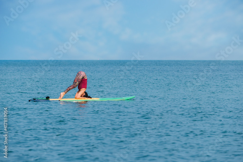 women yoga on paddle board in the sea.