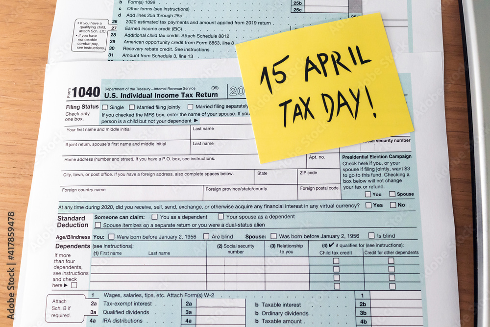 Fototapeta premium Tax day. 1040 form and calculator on table ready to be filled and returned.