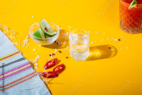 Mexican alcohol tequilas with lime appetizer and sangrita drink. Yellow background. photo