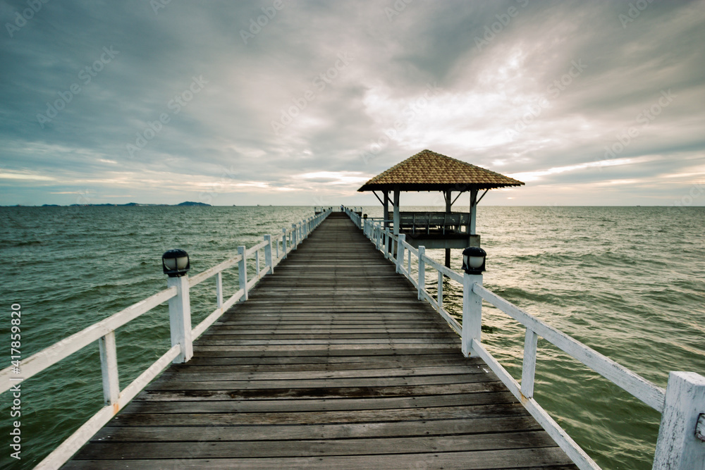 wood bridge in evening at Casaluna village in Thailand , wooden pier on the beach ,Wooded bridge in the port between sunrise.