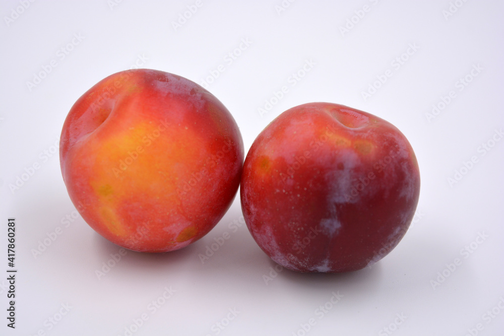 Delicious useful fruits, red, cherry ripe plums located on a white background. Delicious useful fruits, red, cherry ripe plums located on a white background.