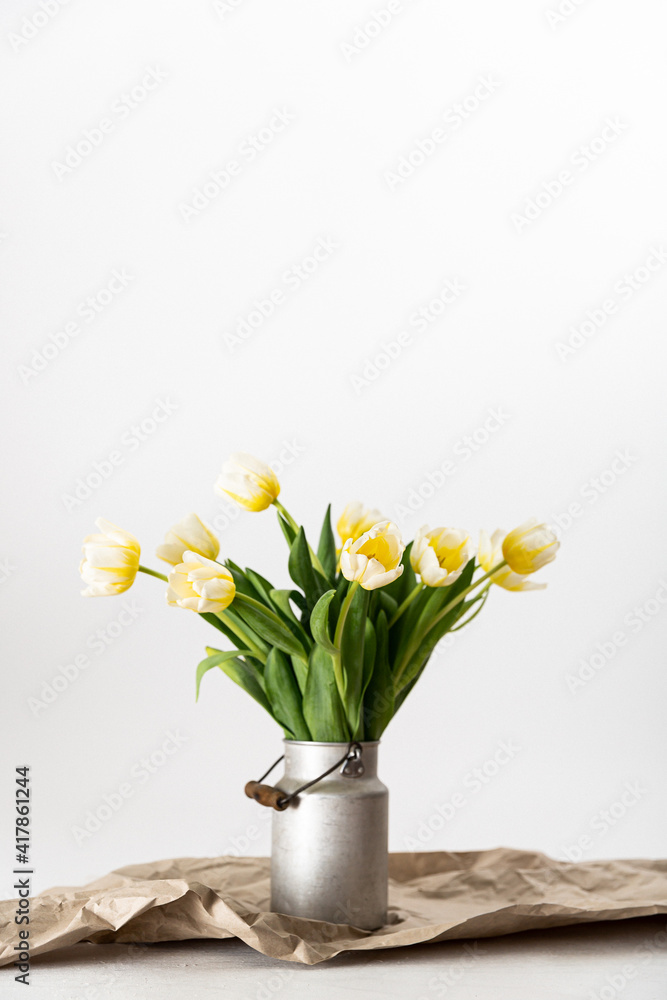 gelb weiße Tulpen in einer Zink Milchkanne auf braunem Packpapier vor weißem Hintergrund arrangiert - minimalistisch, shabby chic, skandinavisch, rustikal, boho, modern, Tulpenstrauß, Blumendeko gelb weiße Tulpen in einer Zink Milchkanne auf braunem Packpapier vor weißem Hintergrund arrangiert - minimalistisch, shabby chic, skandinavisch, rustikal, boho, modern, Tulpenstrauß, Blumendeko