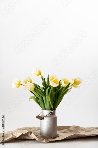 gelb weiße Tulpen in einer Zink Milchkanne auf braunem Packpapier vor weißem Hintergrund  arrangiert - minimalistisch, shabby chic, skandinavisch, rustikal, boho, modern, Tulpenstrauß, Blumendeko