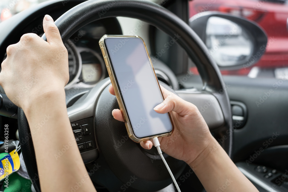Woman driver using a smartphone in car. Woman driver using a smartphone in car.