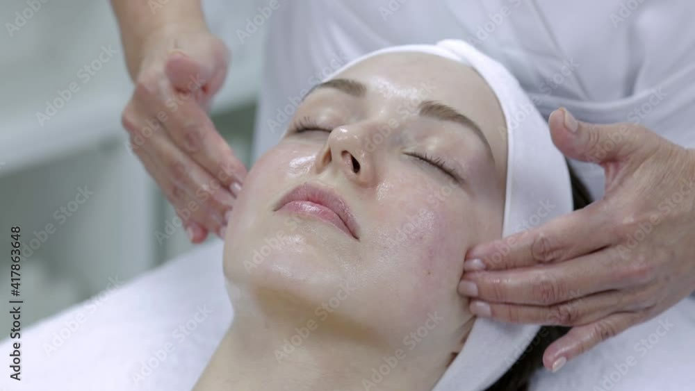 Young beautiful woman getting facial massage process cleaning and treatment relaxing at spa. Young beautiful woman getting facial massage process cleaning and treatment relaxing at spa.