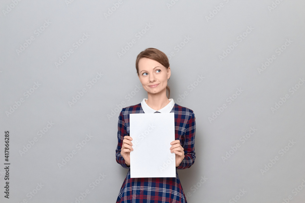 Portrait of happy woman holding white blank paper sheet in hands Portrait of happy woman holding white blank paper sheet in hands