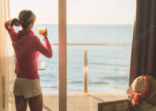 girl looking through a window, just got up and drank a fresh orange juice. She is looking at the Mediterranean sea with a beautiful light. © Karlos Garciapons