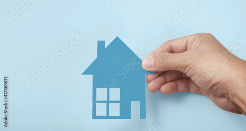Hands holding paper house  family home  protecting insurance concept