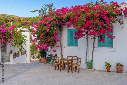 Picturesque alley in lefkes Paros greek island with a full blooming bougainvillea !! Whitewashed traditional houses   and flowers all over !!! photo
