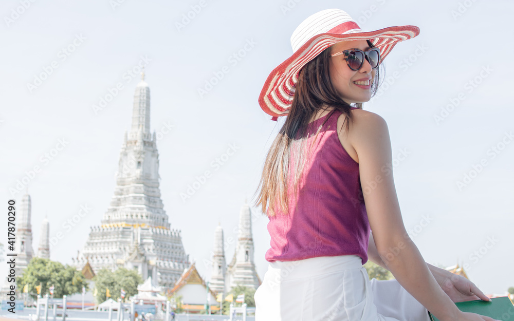Woman wearing hat, sitting near river and travelling