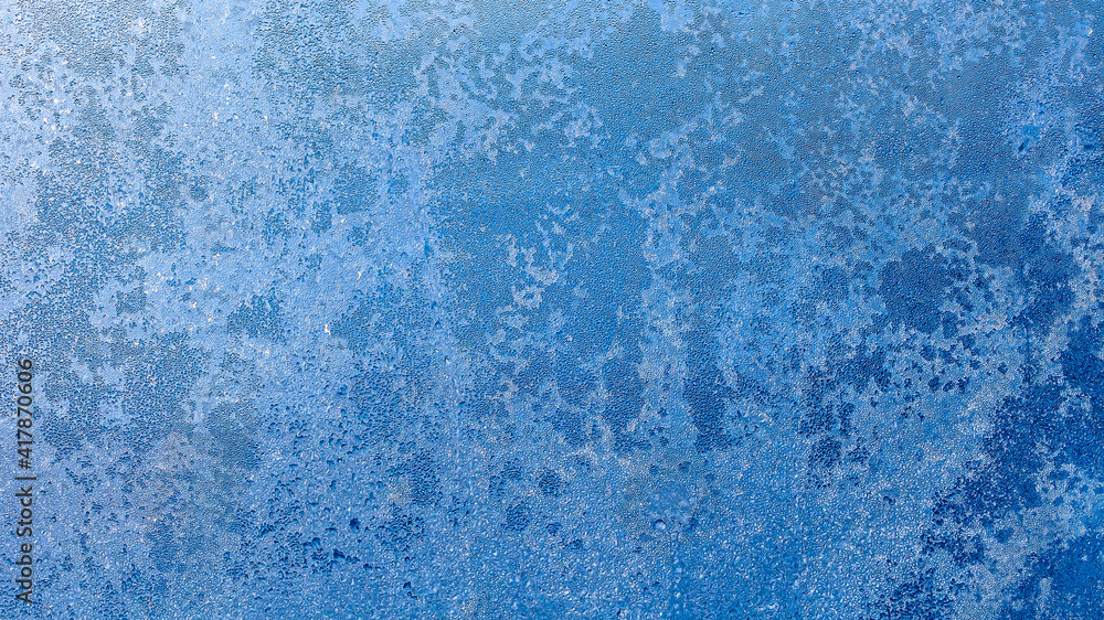 Obraz premium Blurred frosty pattern on glass window wirh bokeh. Luxury shining glowing textured background for graphic design and wallpaper. Copy space for text