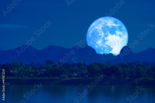 full blue worm blue moon rise back silhouette mountain blur dark cloud on the night sky