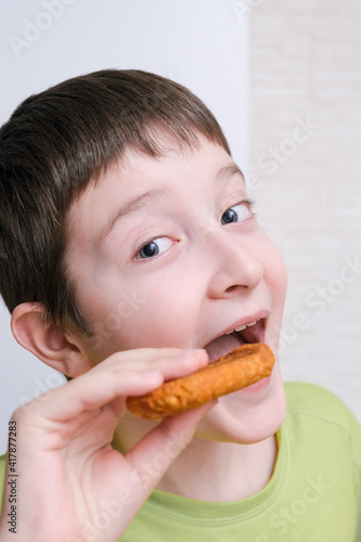 A portrait of a preteen boy eating tasty cookie  snacking concept