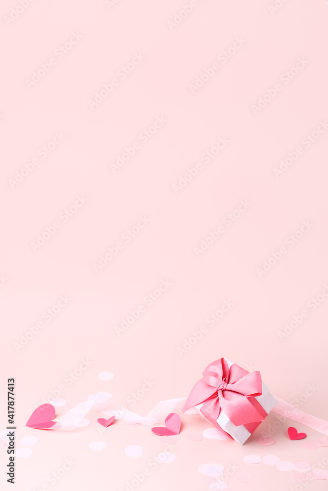 Stylish gift box with big pink bow and tender paper craft pink hearts on pink background, copy space, Greeting card, banner, flyer, postcard for Saint Valentine day, romance holiday, wedding, birthday