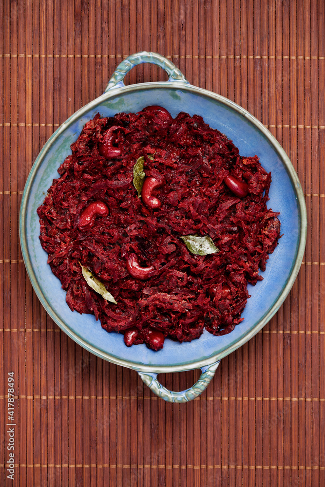 Beetroot curry made from grated beetroot with coconut milk, grated coconut and cashews. Indian cuisine meal in plate placed on black slate. Top view. Beetroot curry made from grated beetroot with coconut milk, grated coconut and cashews. Indian cuisine meal in plate placed on black slate. Top view.