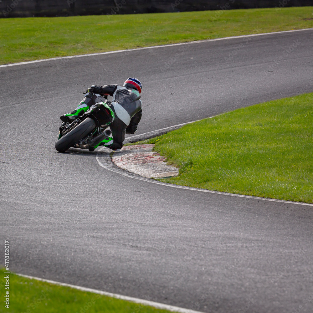 A shot of a racing motorbike as it circuits a track.