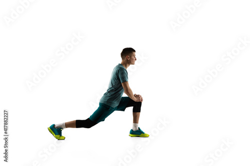 Squats. Young caucasian male model in action, motion isolated on white background with copyspace. Concept of sport, movement, energy and dynamic, healthy lifestyle. Training, practicing. Authentic.