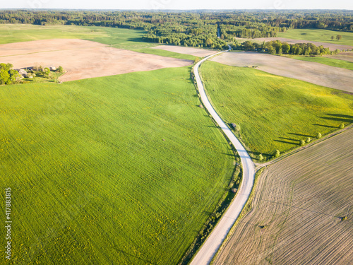 Aerial View of Dirt Road Separating Green Meadow and Brown Agricultural Field