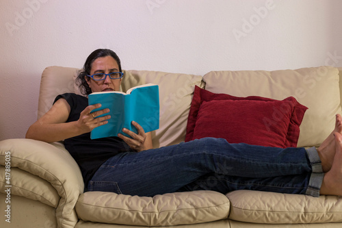 a girl enjoying a book on a sofa